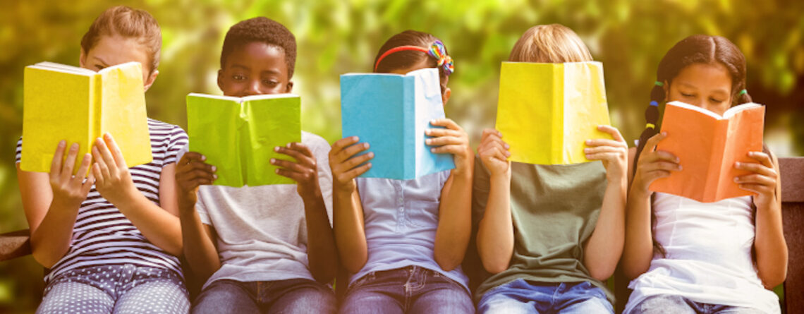 Kinder sitzen vor Büchern und lesen