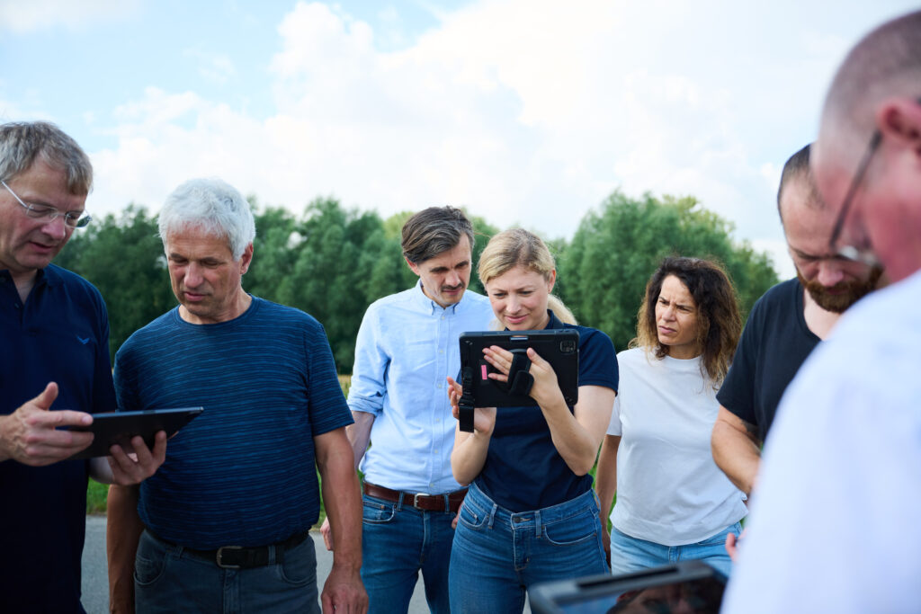Teilnehmer*innen und das LEKA Mitarbeiterin probieren zusammen Augmented Reality aus