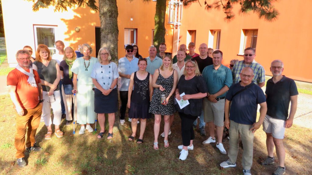 Gruppenfoto von Mitgliedern der Bürgerenergiegenossenschaft vor KITA Gebäude