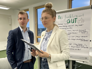 Jens Bieker von der Agentur für Klimaschutz und Caral Fee Weisse von der LEKA MV stehen vor einem Flipchart