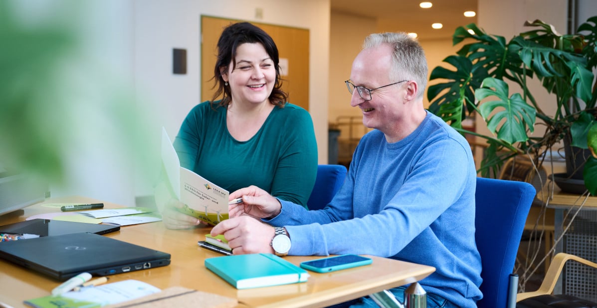LEKA Mitarbeiter am Schreibtisch Zwei Mitarbeiter der LEKA arbeiten gemeinsam am Schreibtisch und haben Spaß dabei