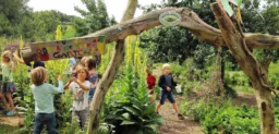 Kinder haben Spaß in einem Garten, der sehr naturnah gestaltet wurde