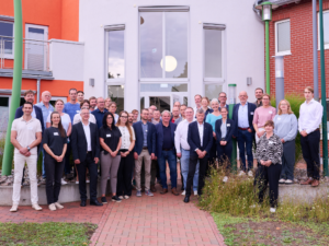 Gruppenfoto der Teilnehmenden des Kommunalnetzwerks West der Landesenergie- und Klimaschutzagentur Mecklenburg-Vorpommern vor den Stadtwerken Grevesmühlen.