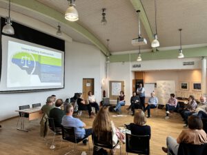 Teilenhmende eines Workshops sitzen im Kreis.
